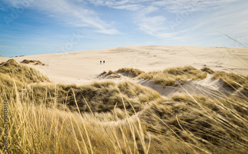 Desert walk. Two men walking on sand dunes.