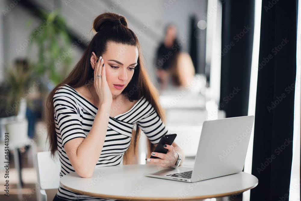 Shocked woman holding and looking sadly at mobile phone, she is disappointed and puzzled with received message. Shocked woman holding and looking sadly at mobile phone, she is disappointed and puzzled with received message.