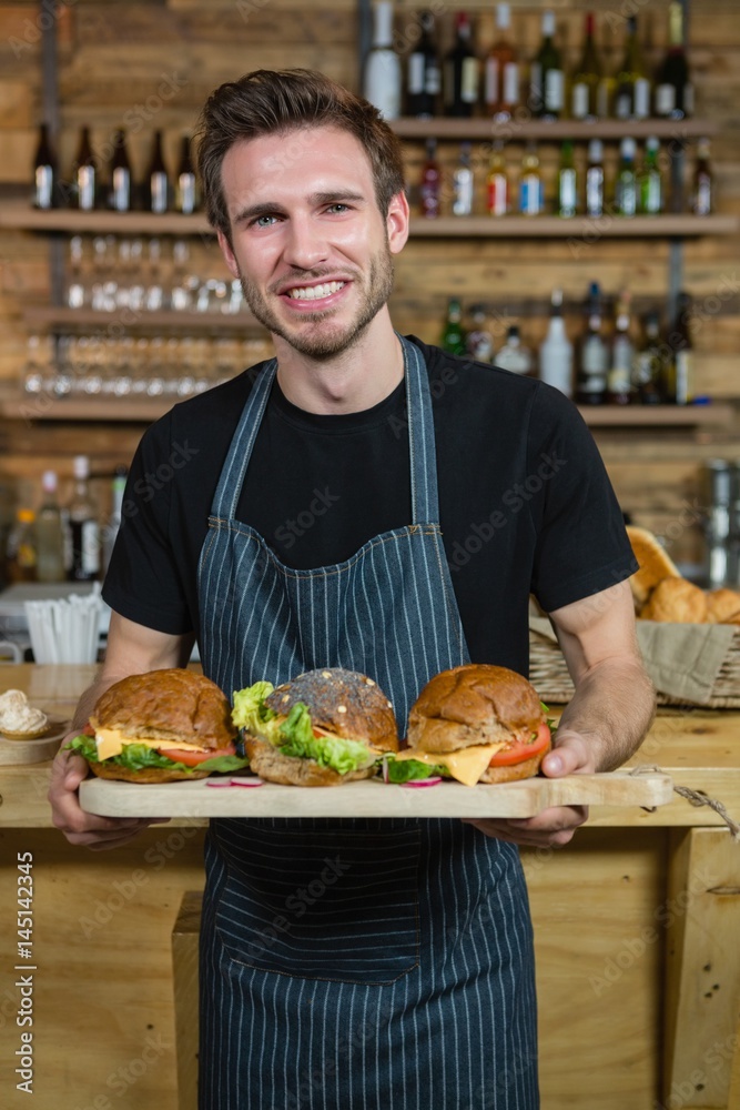 Portrait of waiter holding food at counter Portrait of waiter holding food at counter