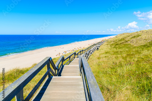 Wooden walkway along a coast of North Sea and view of beautiful beach near Wenningstedt village  Sylt island  Germany