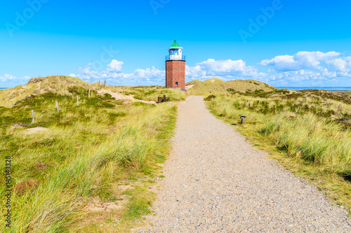 Lighthouse on green field in countryside landscape of Sylt island, Germany