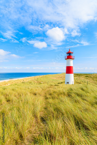 Ellenbogen lighthouse on sand dune against blue sky with white clouds on northern coast of Sylt island  Germany