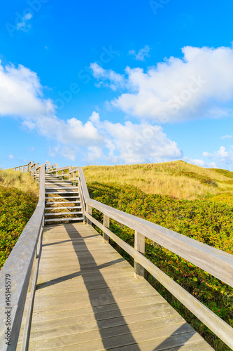 Wooden walkway along a coast of North Sea and view of beautiful beach near Wenningstedt village  Sylt island  Germany