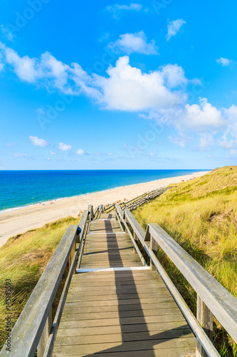 Wooden walkway along a coast of North Sea and view of beautiful beach near Wenningstedt village, Sylt island, Germany © pkazmierczak