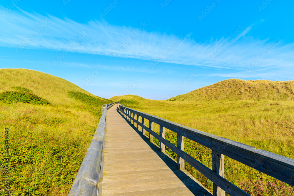 Wooden footbridge from sand dune to beautiful beach near Westerland village, Sylt island, Germany