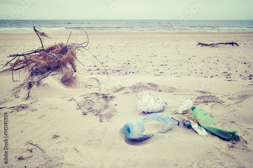 Vintage toned picture of garbage left on a beach  environmental pollution concept picture  selective focus.
