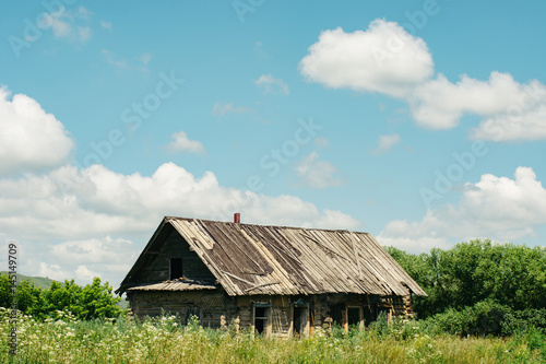 Abandoned wooden house in the middle of the overgrown area. Village.