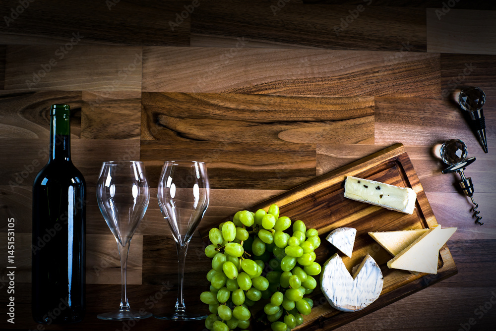Obraz premium Wine bottles with grapes and cheese on wooden rustic background. copy space