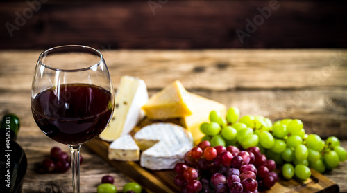  Wine bottles with grapes and cheese on wooden rustic background. copy space