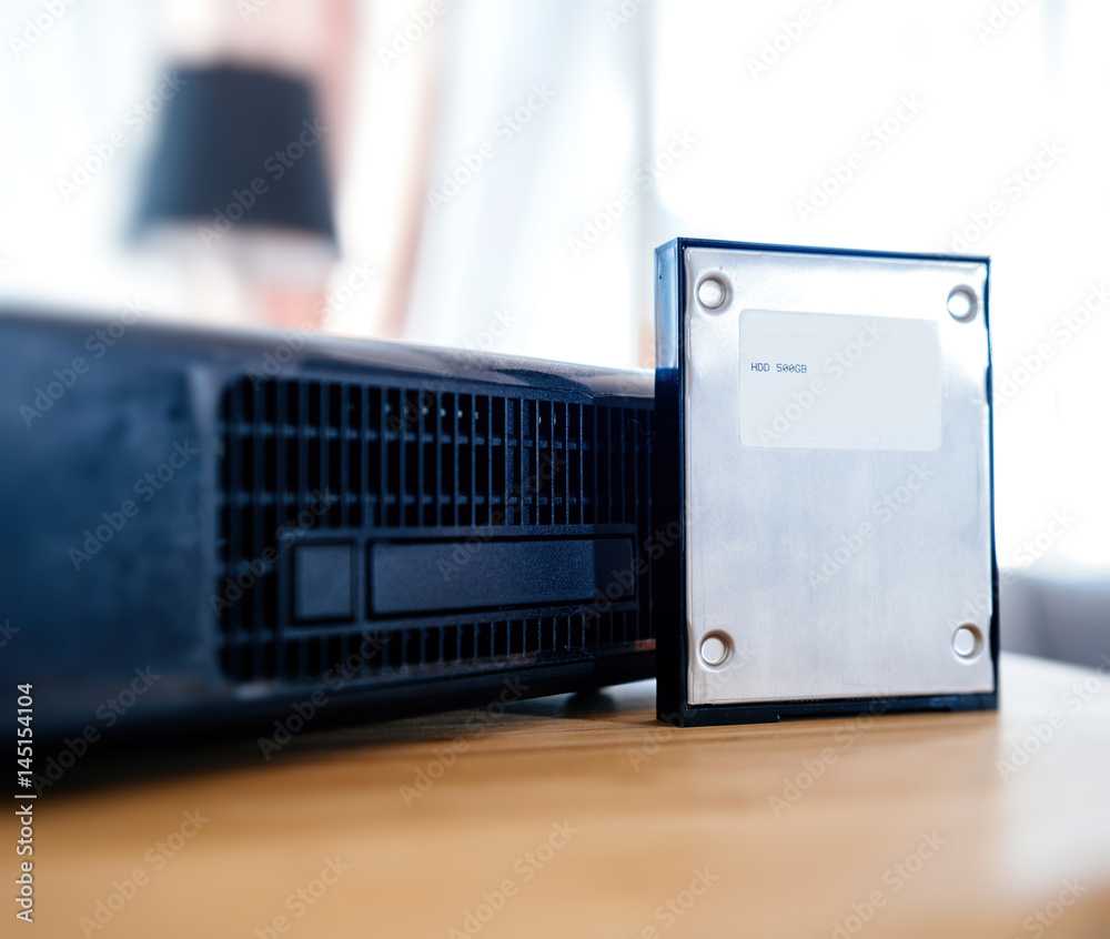 2.5 HDD hard disk drive next to wireless tv box used for TV Internet  Telephone communication via fiber optic or coaxial cable Stock Photo |  Adobe Stock