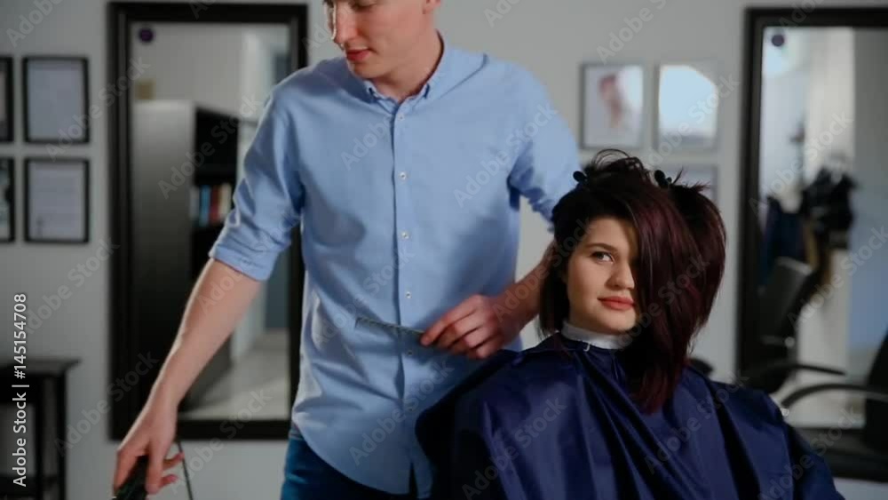 Reflection of hairdresser doing haircut for woman in hairdressing salon. Concept of fashion and beauty
