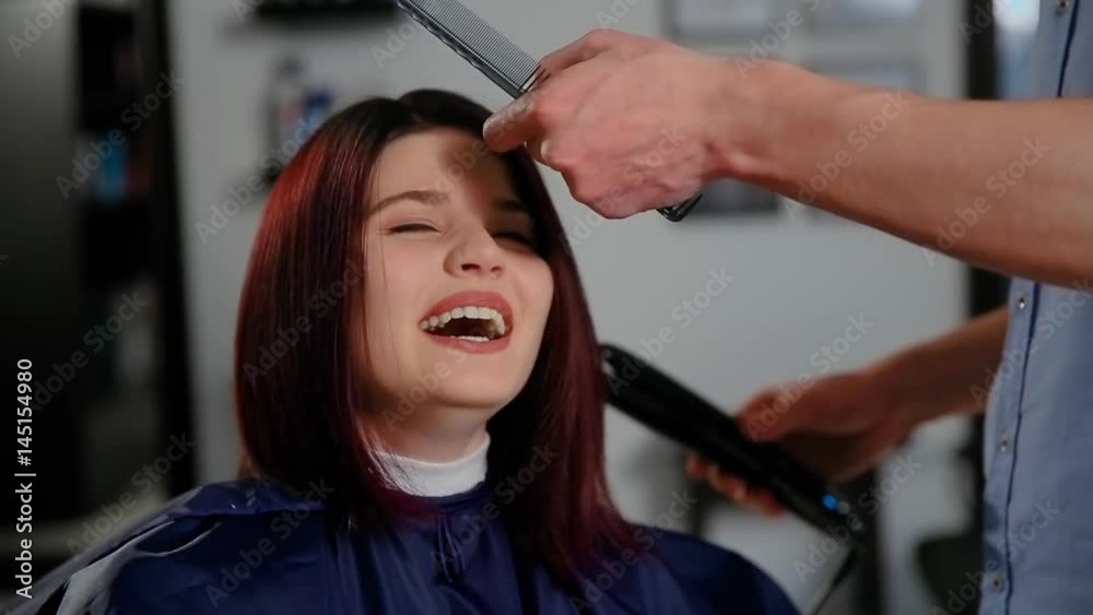Reflection of hairdresser doing haircut for woman in hairdressing salon. Concept of fashion and beauty Reflection of hairdresser doing haircut for woman in hairdressing salon. Concept of fashion and beauty