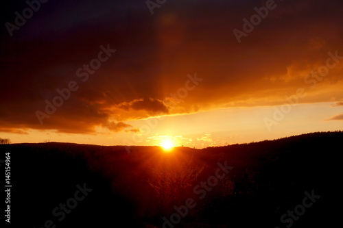 sunset landscape small mountain with clouds in the sky red