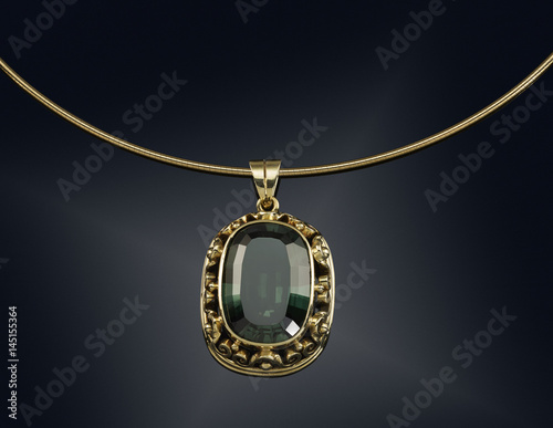 Golden necklace with gemstone isolated on black