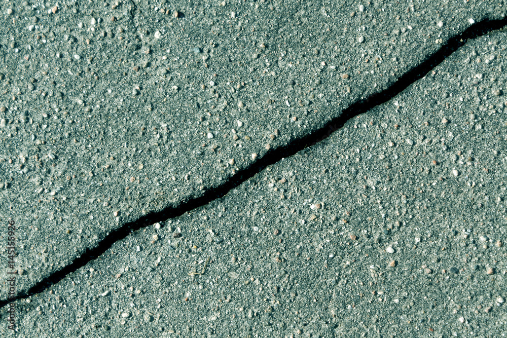 Obraz premium Crack on cyan asphalt surface.