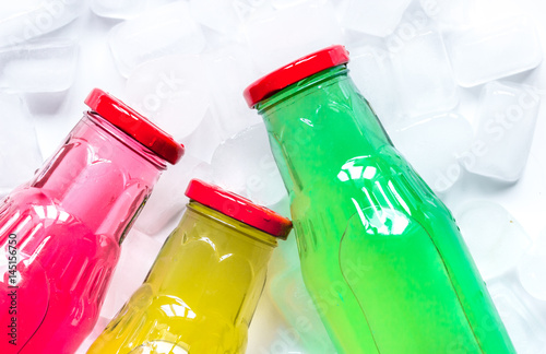 fruit drinks in colorful plastic bottles with ice top view mock-up