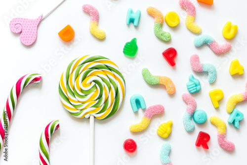 Colorful candies on white texture background top view pattern