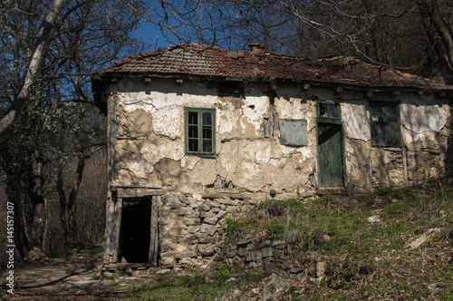 Old abandoned grunge rural country house in springtime mountain