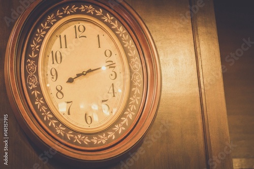 Old clock hanging on the wooden wall