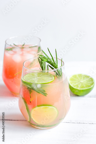 fitness cocktail in glass with lime and rosemary on white table background