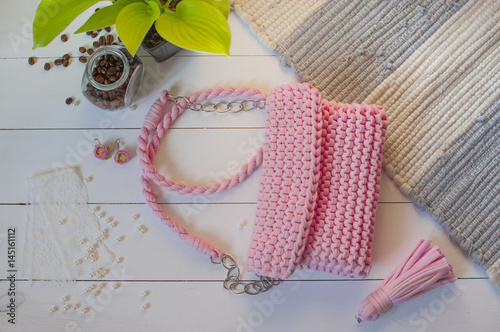 Female handbag handmade pink color on a white background with a jar of coffee and beads