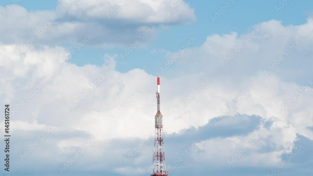 Global network telecommunication symbol, aerial tower over blue cloudy sky timelapse, zoom out with tower in the middle Global network telecommunication symbol, aerial tower over blue cloudy sky timelapse, zoom out with tower in the middle