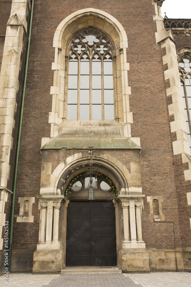 Entrance to the church with the wrought iron door and big gothic window