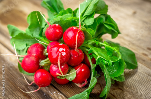 Bunch of fresh red radishes on a wooden table