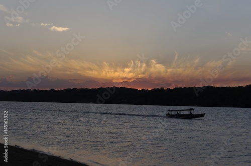 pirogue sur le fleuve Oyapock, Brésil au coucher du soleil photo