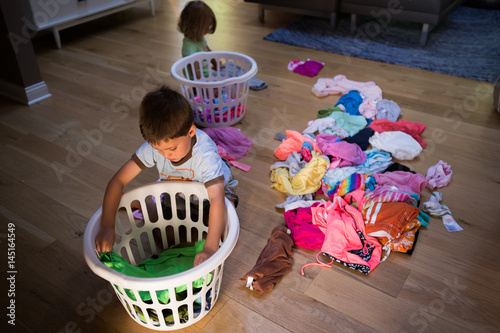 Children sitting on floor with washing baskets photo