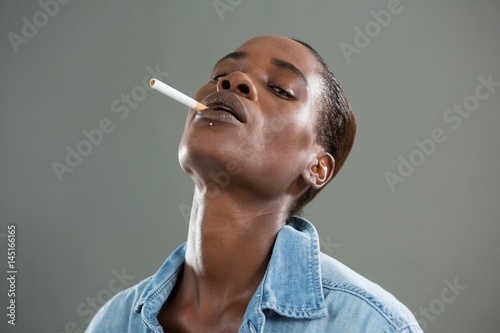 Obraz na plátně Androgynous man posing with cigarette in his mouth