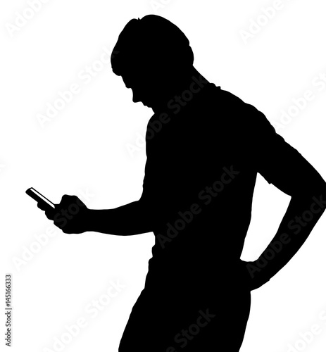Side profile portrait silhouette of teenage boy texting on smart phone