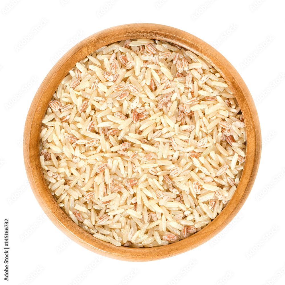 Sparkling Volcano Terra rice in wooden bowl. Brown, red and pink natural rice. Rice of warriors from Tasikmalaja region of West Java. Isolated macro food photo close up from above on white background. Sparkling Volcano Terra rice in wooden bowl. Brown, red and pink natural rice. Rice of warriors from Tasikmalaja region of West Java. Isolated macro food photo close up from above on white background.