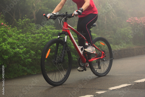 cyclist riding mountain bike on foggy forest trail