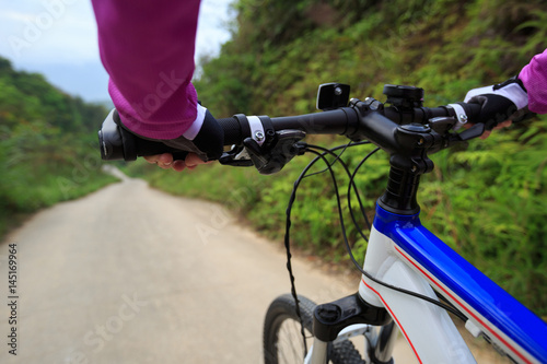 cyclist riding mountain bike on foggy forest trail