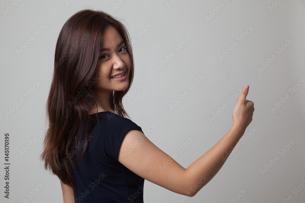 Young Asian woman turn back thumbs up. Young Asian woman turn back thumbs up.