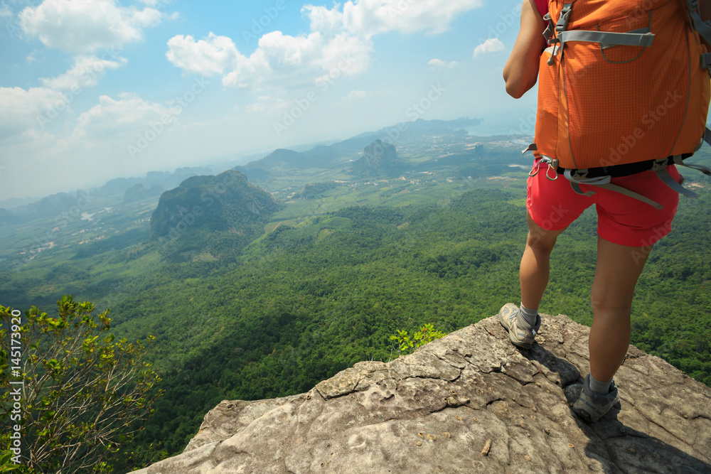 Obraz premium young woman backpacker hiking at mountain top