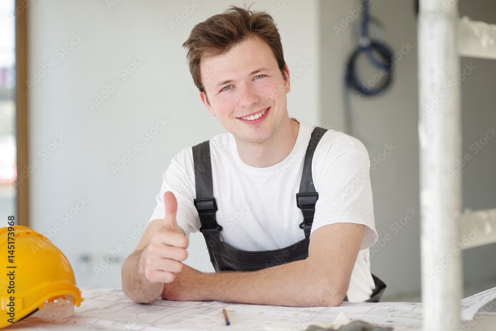 Handwerker positiv lächelnd auf einer Baustelle Handwerker positiv lächelnd auf einer Baustelle