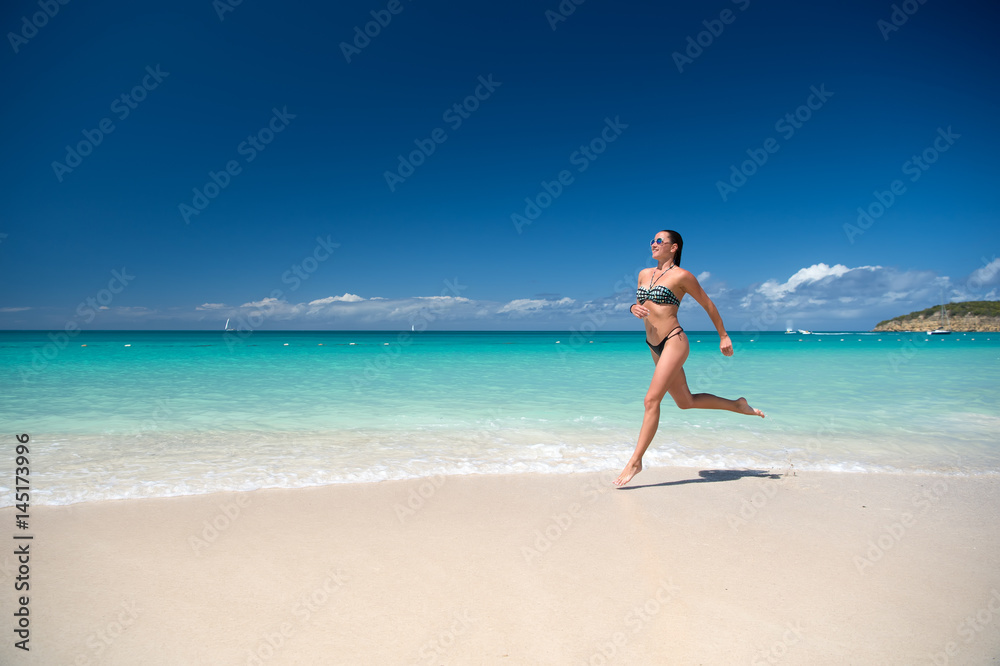 Young woman running at the tropical beach
