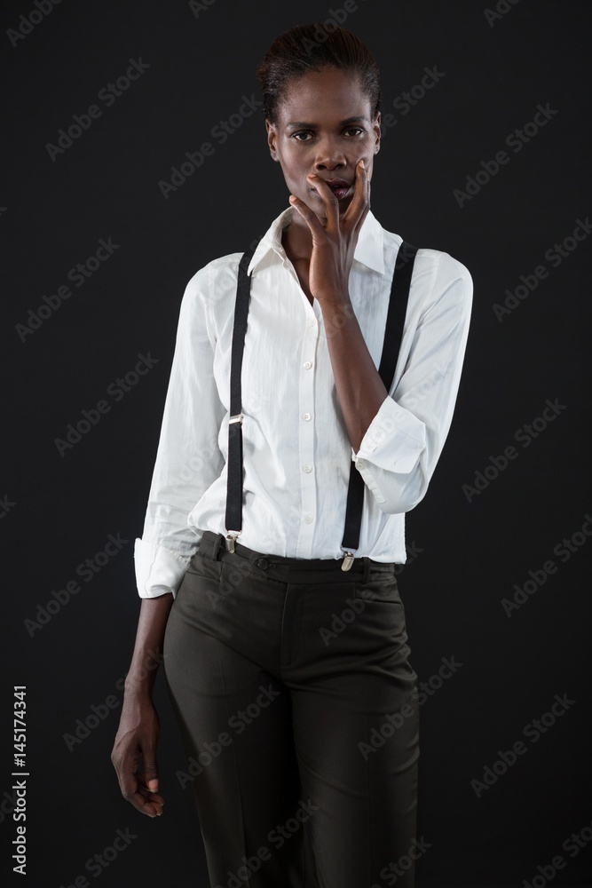 Androgynous man standing with hands on his face Androgynous man standing with hands on his face