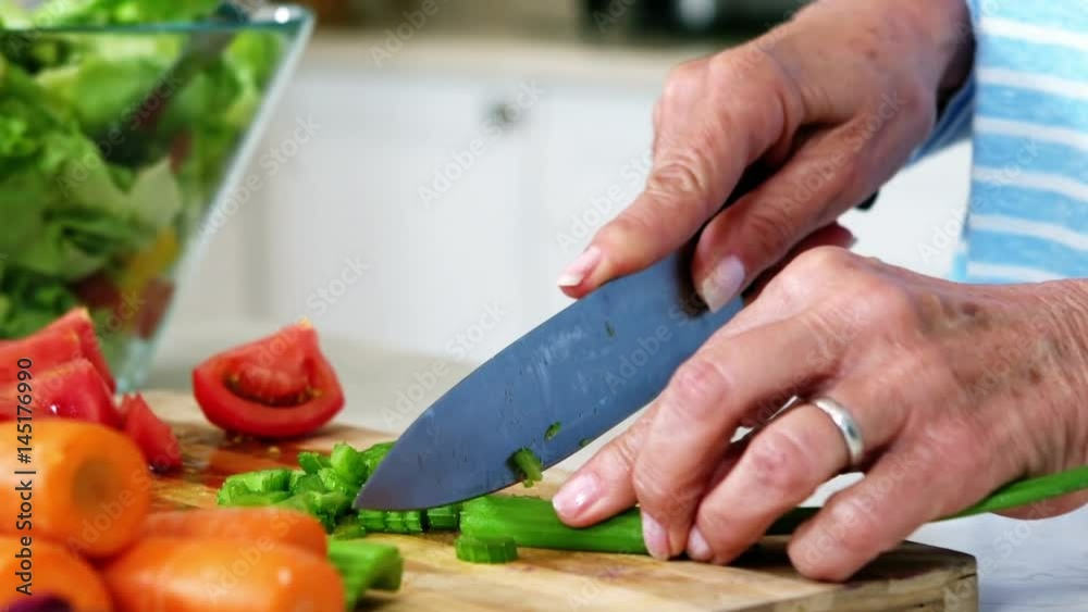 Hands of senior woman preparing vegetable salad Hands of senior woman preparing vegetable salad
