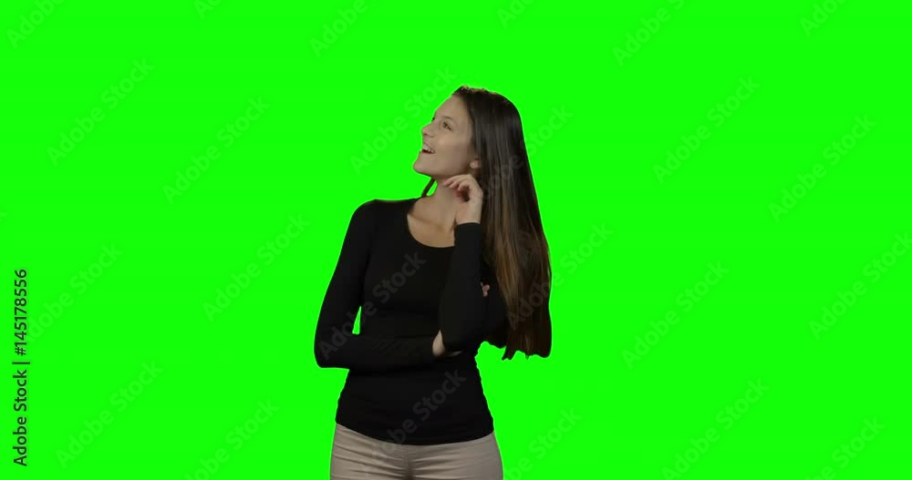 Smiling woman looking around against green screen Smiling woman looking around against green screen
