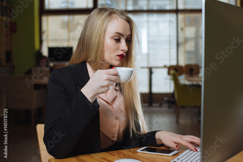Young business woman drink coffee in office