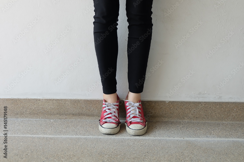 Feet From Above Concept, Teenage Person in Red Sneakers Standing on Ground Background Great for Any Use. Feet From Above Concept, Teenage Person in Red Sneakers Standing on Ground Background Great for Any Use.