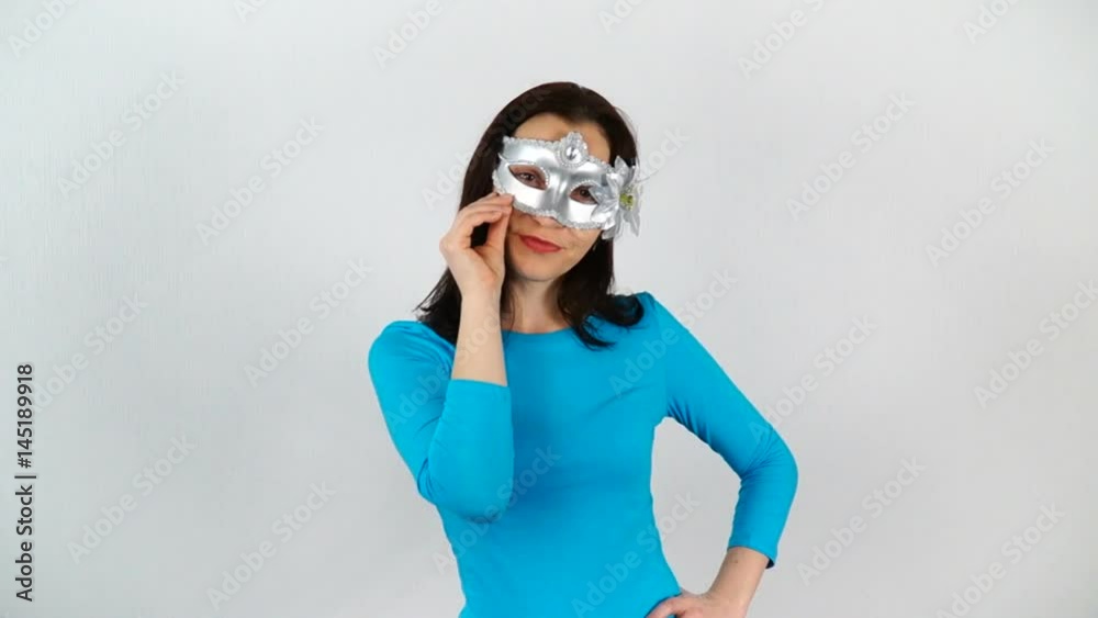 A model on a white background with a glass of red wine. The woman put on a carnival mask. A model on a white background with a glass of red wine. The woman put on a carnival mask.