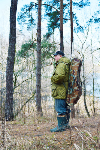 Mature caucasian man with backpack in the forest