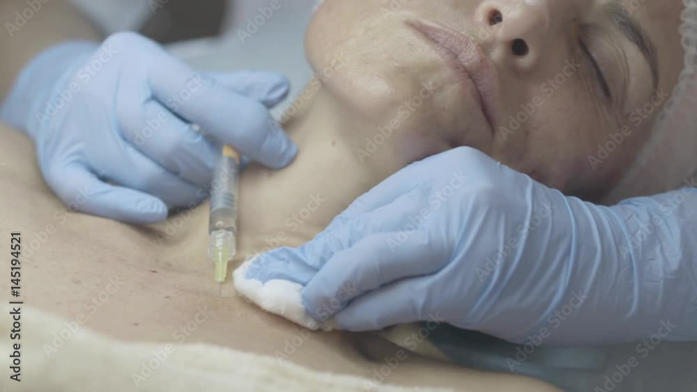 Close-up of a young woman who getting botox injections in her neck and breast in the beauty salon, slow motion Close-up of a young woman who getting botox injections in her neck and breast in the beauty salon, slow motion