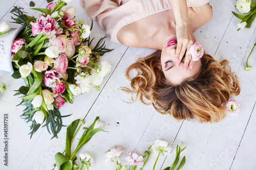 Portrait of a young blonde woman in flowers. Woman's face with make-up and hairstyle