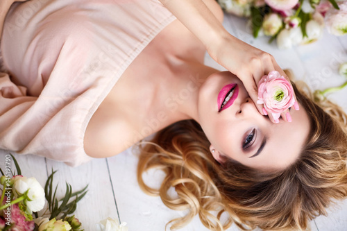 Portrait of a young blonde woman in flowers. Woman's face with make-up and hairstyle