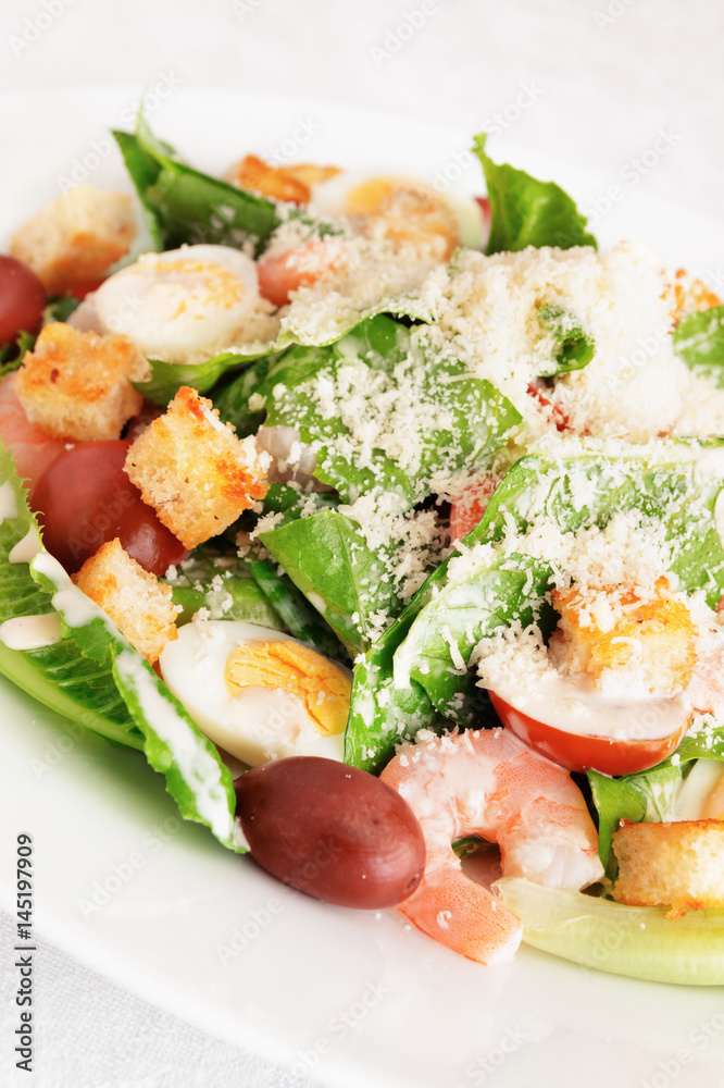 salad of romaine lettuce with prawns, quail eggs, croutons, cherry tomatoes, and kalamata olives with caesar dressing and grated parmesan salad of romaine lettuce with prawns, quail eggs, croutons, cherry tomatoes, and kalamata olives with caesar dressing and grated parmesan